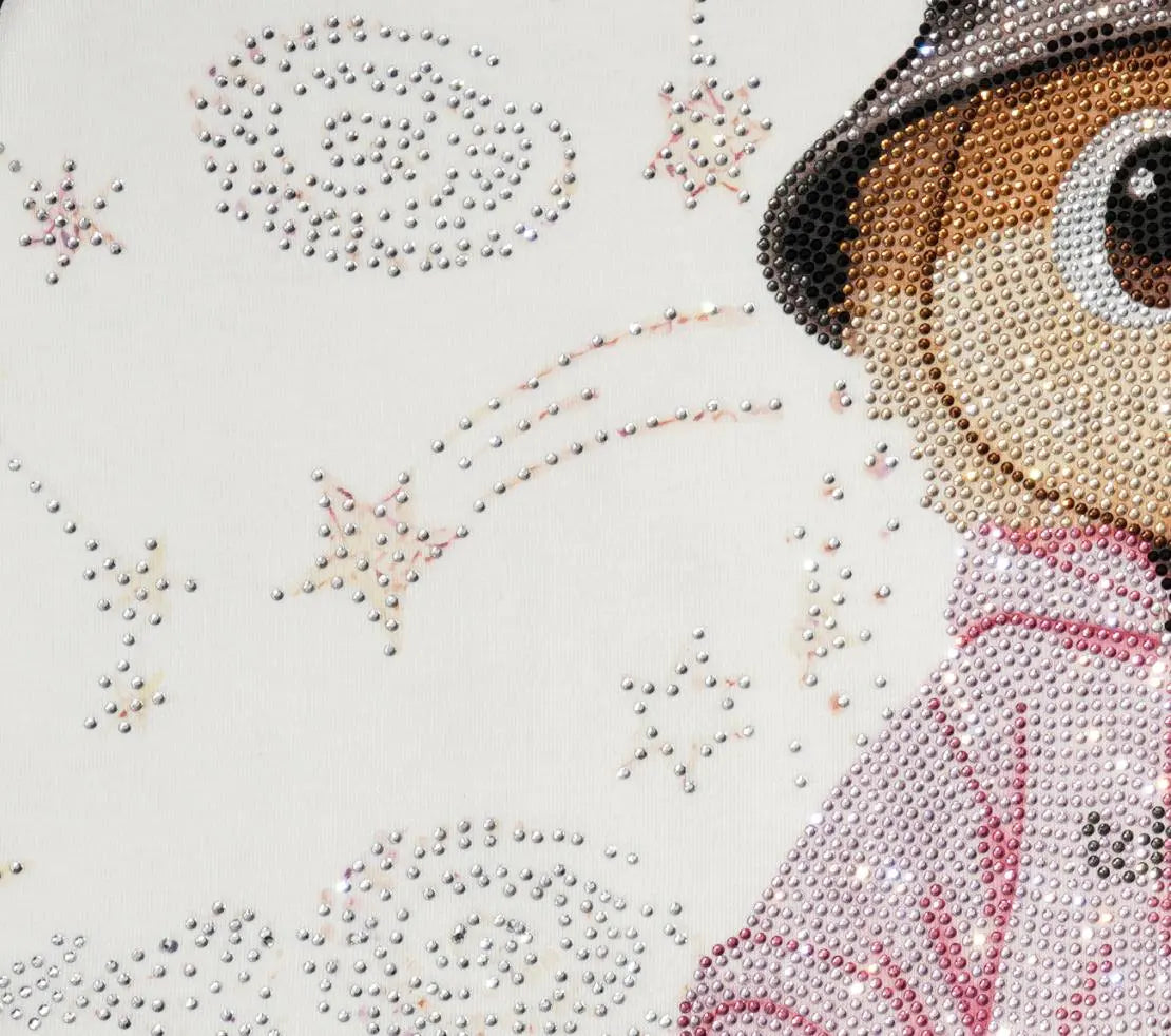Close-up of a diamond painting or rhinestone art design featuring a cartoon character wearing a brown hat and pink jacket, surrounded by stars and shooting stars on a white background. TCH Rhinestone Teddy Bear Techno Raglan T-Shirt