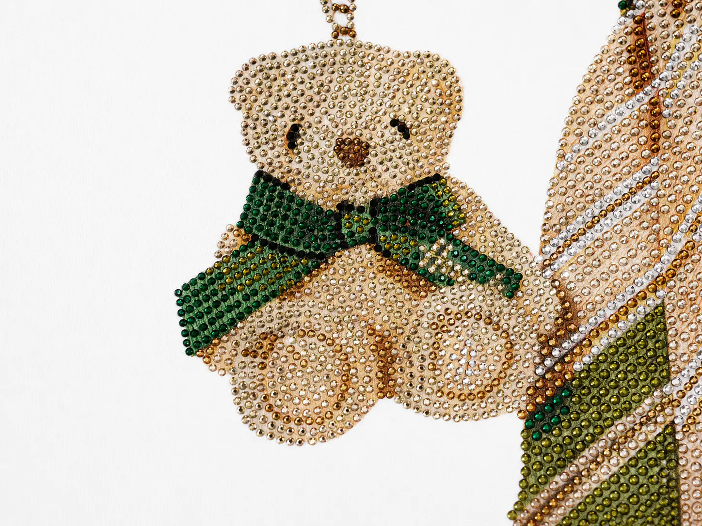 A close-up of a teddy bear-shaped accessory covered in small beige rhinestones, wearing a green rhinestone bow and scarf, against a plain white background. TCH Rhinestone Teddy Bear Tie Graphic White T-Shirt