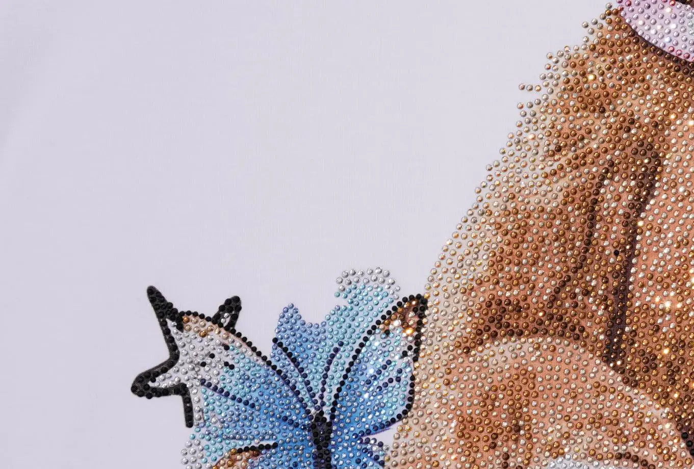 Close-up of a diamond painting or rhinestone art piece showing a blue butterfly and a brown animal, likely a bear, on a white background. TCH Rhinestone Teddy Bear White T-Shirt