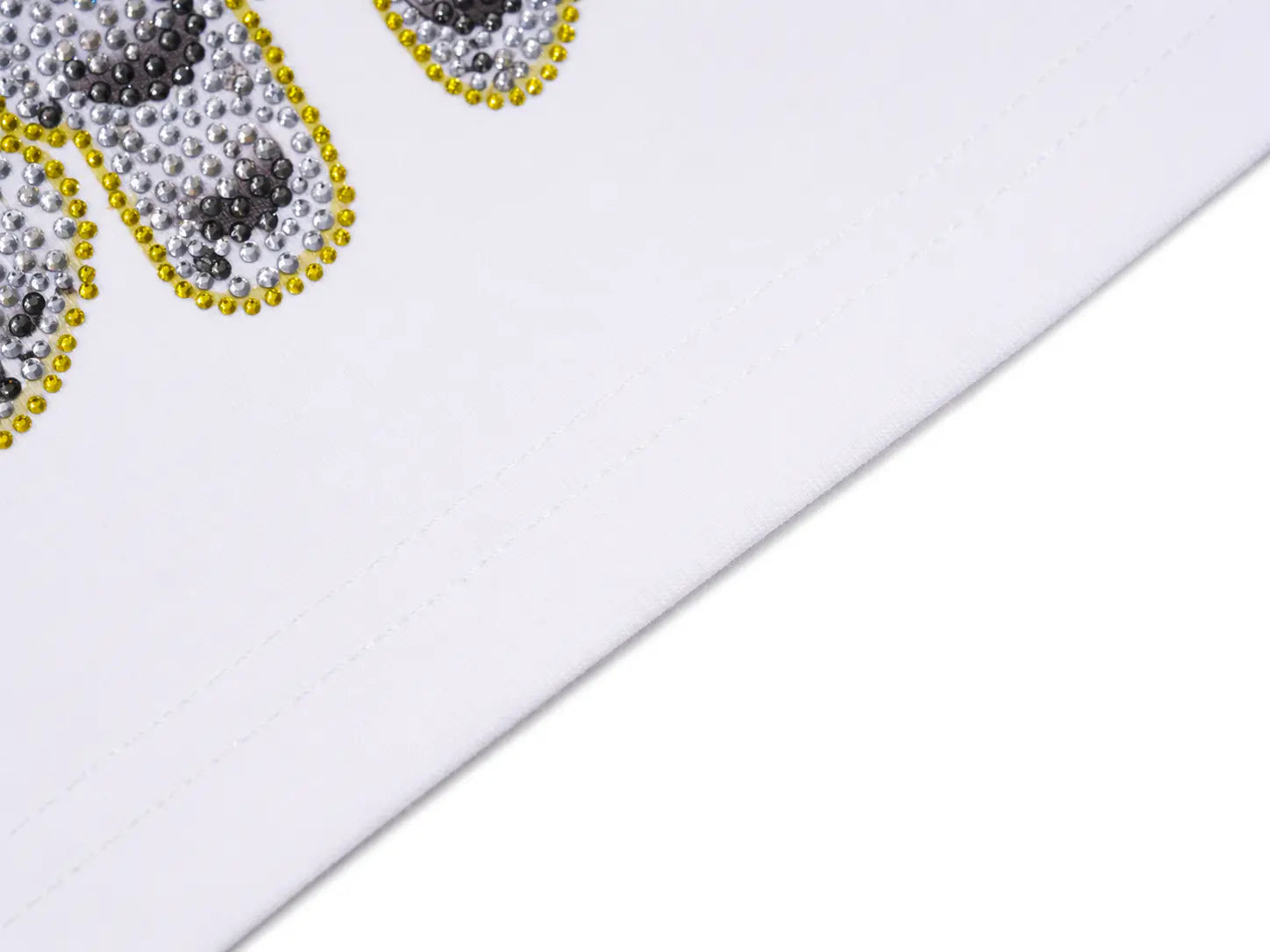 Close-up detail of a white garment featuring a decorative graphic with silver and black rhinestone-like dots outlined in yellow beads. TCH Rhinestone Teddy Bear White T-Shirt