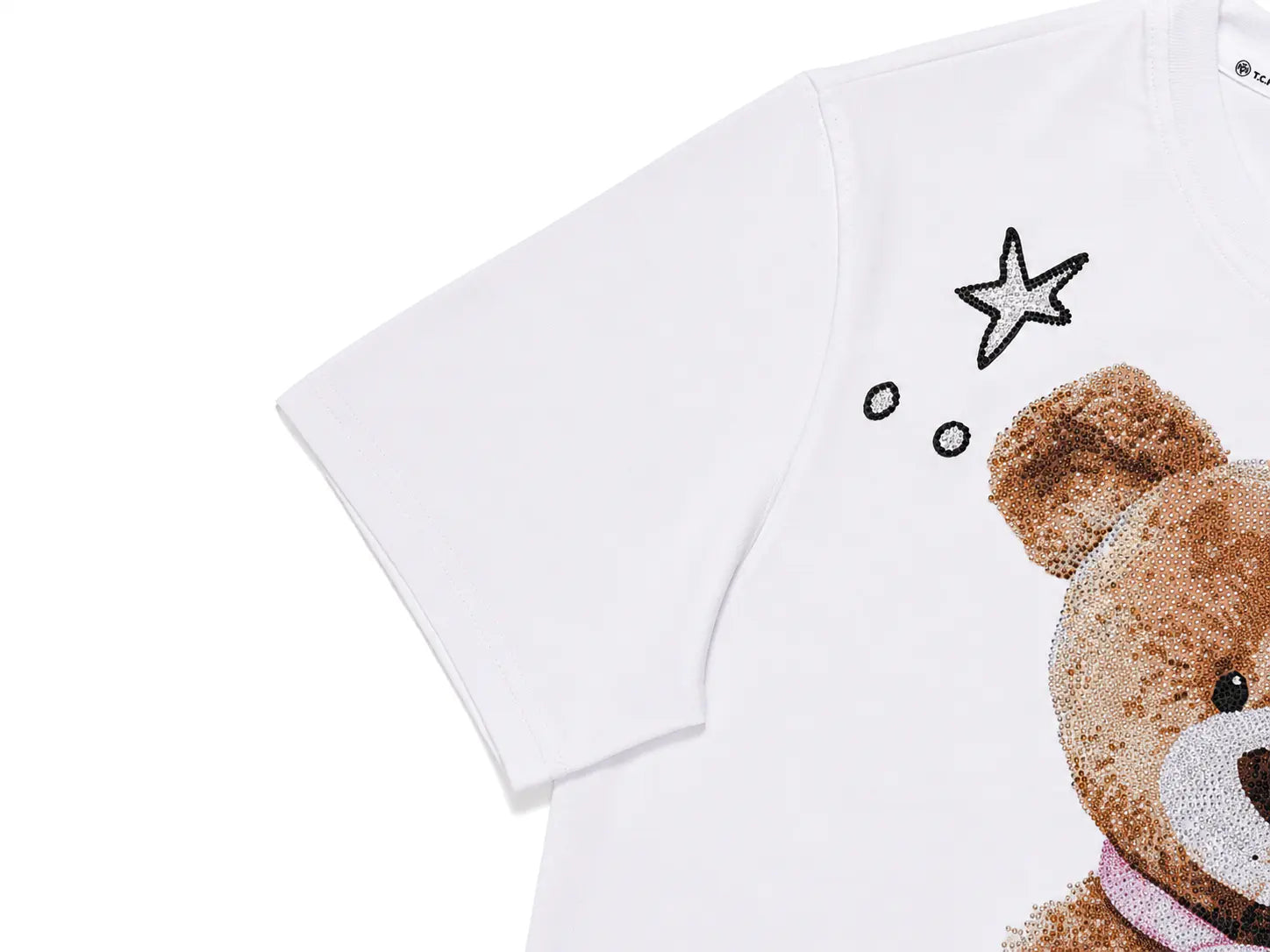 A close-up of a white short-sleeve T-shirt featuring a sequined brown teddy bear graphic and a sequined star detail on the chest. TCH Rhinestone Teddy Bear White T-Shirt