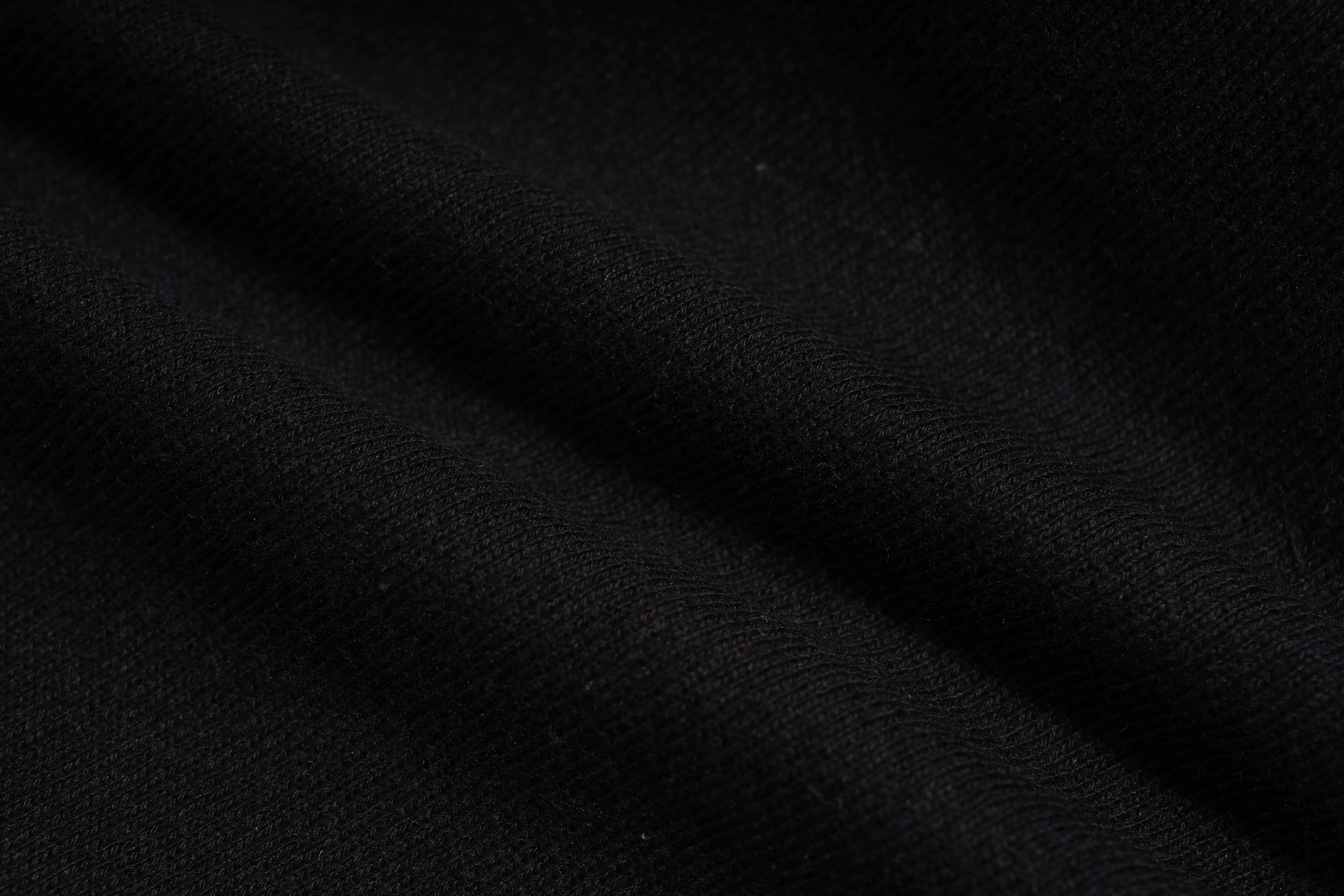 A close-up of black fabric with soft folds and a fine woven texture. TCH Rhinestone Teddy Bear Wing Sleeve Bomber Jacket
