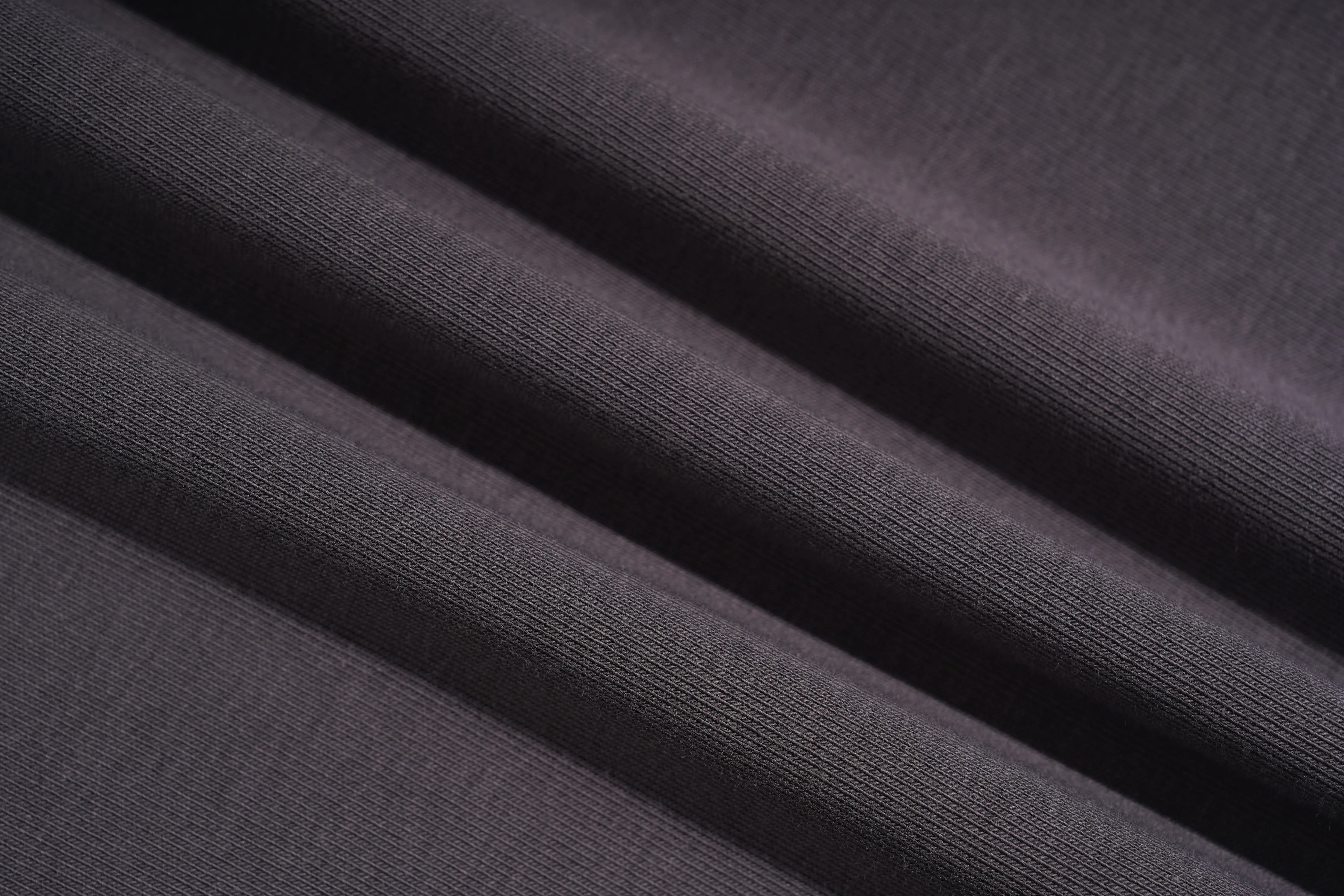 A close-up of dark charcoal gray ribbed fabric with soft diagonal folds showing the texture and weave. TCH Rhinestone Unicorn Graphic Charcoal T-Shirt