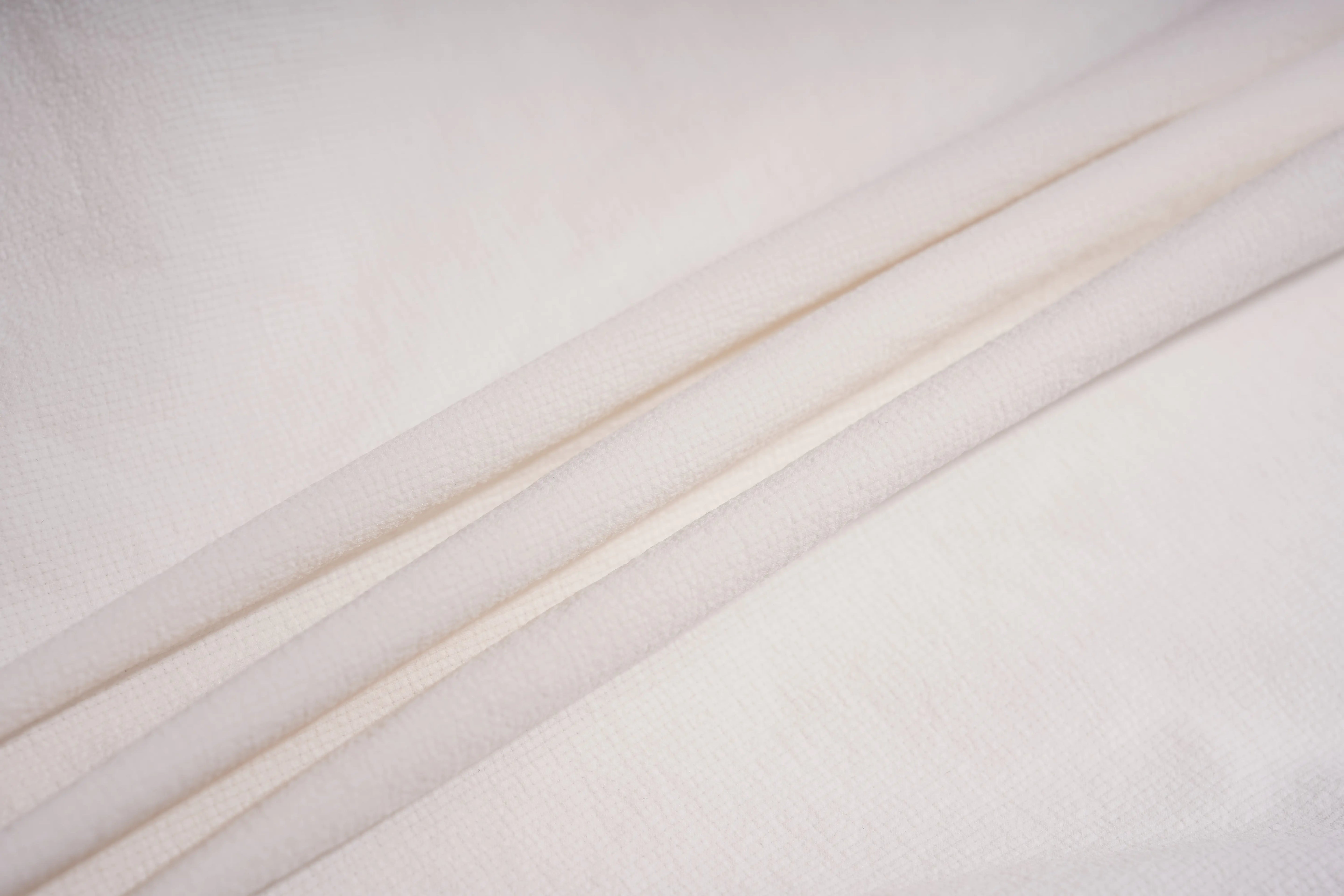 A close-up of draped off-white fabric with soft folds and a subtle woven texture. TCH Rhinestone Wing Active 3-Piece Tracksuit Set