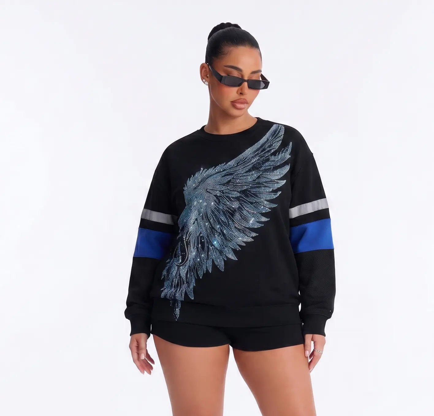 Woman wearing a black sweater with a blue wing design on a white background, TCH Rhinestone Wing Black Crewneck Sweatshirt