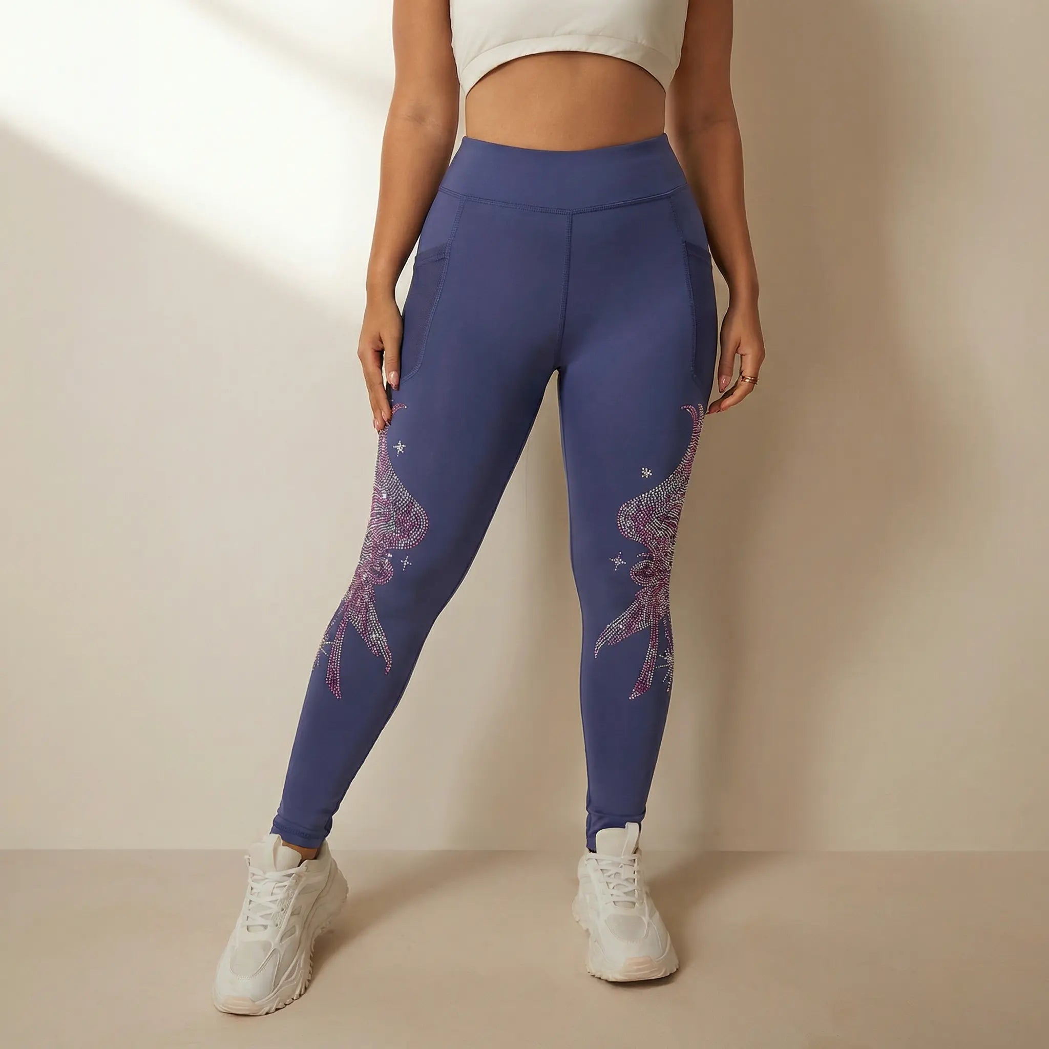 Person wearing blue leggings with star designs on a beige background， TCH Rhinestone Wing Graphic High-Waist Leggings