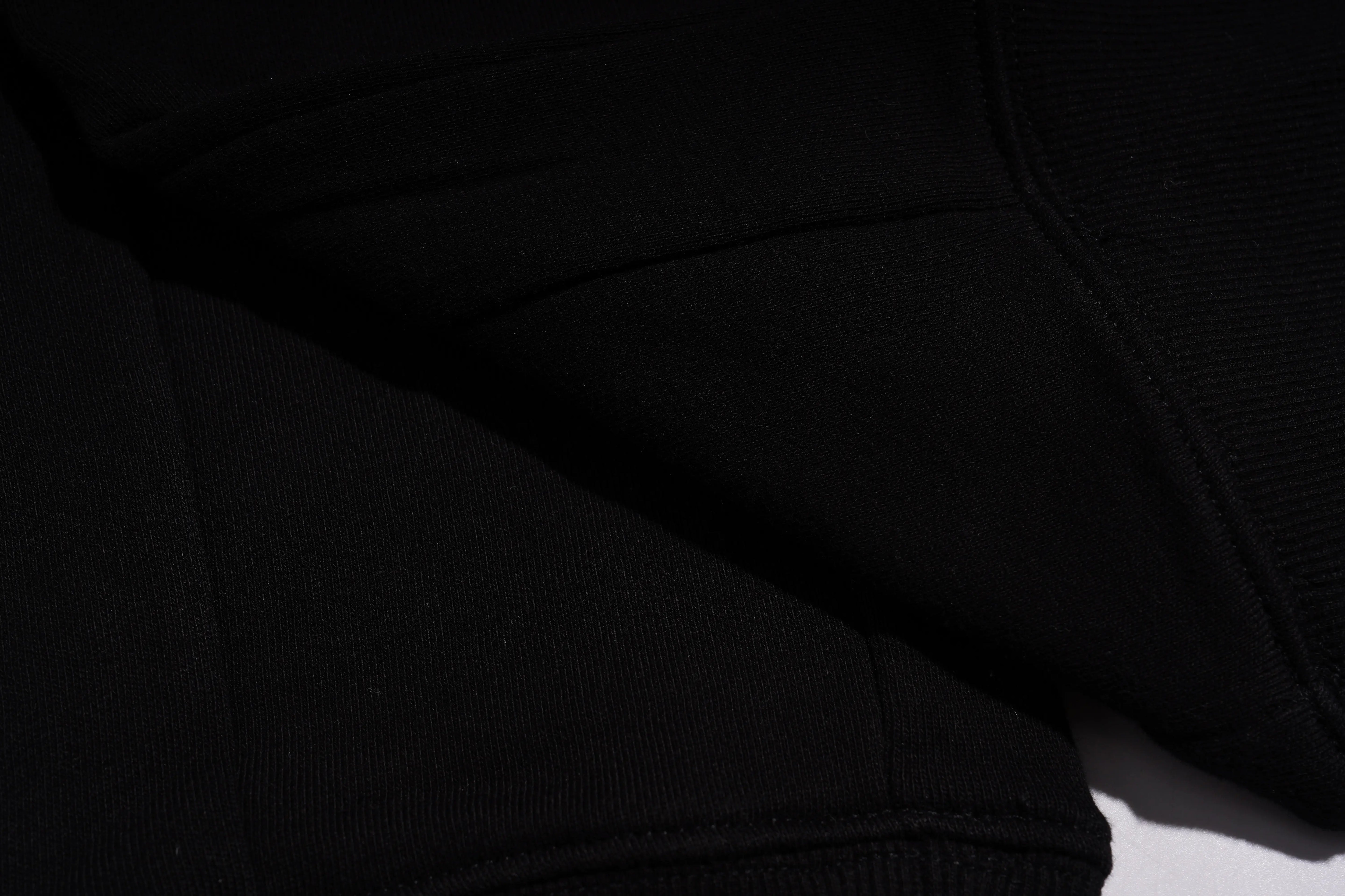Close-up of a black hoodie with a focus on texture and color. TCH Rhinestone Wing Techno Jogger Pants