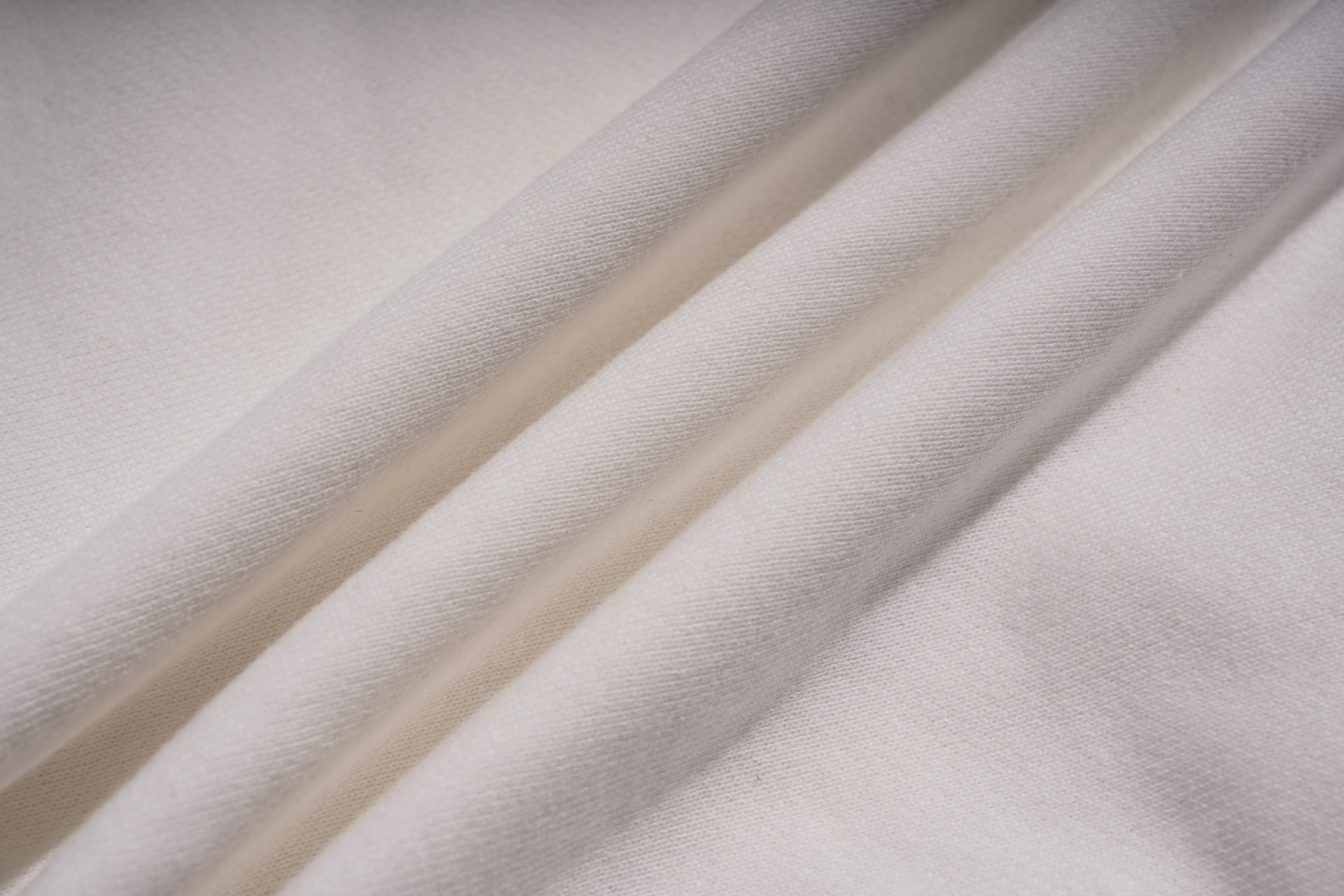 Close-up of textured beige fabric with folds, TCH Rhinestone Winter Lamb Sweatshirt