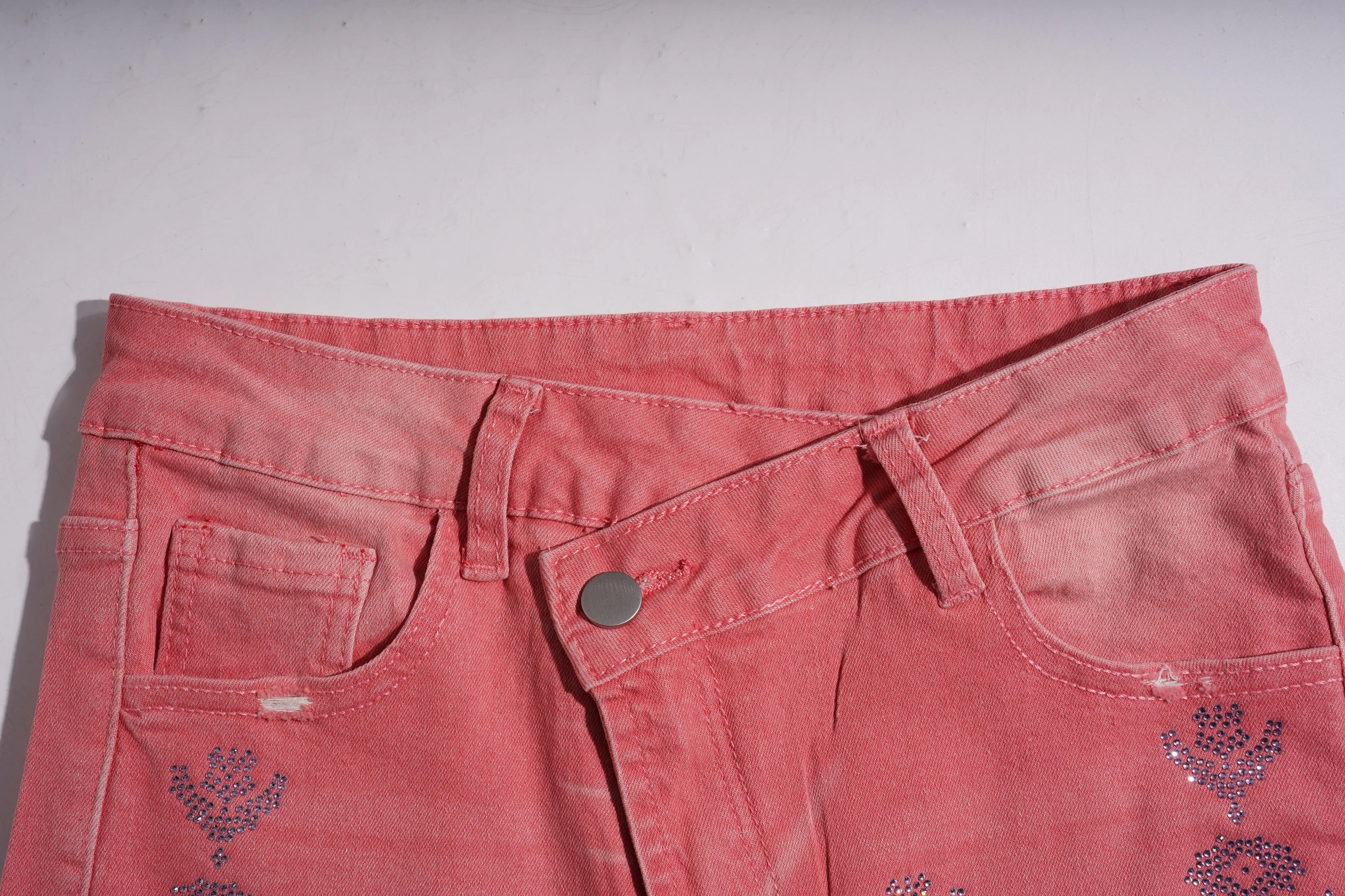 Close-up of pink denim shorts with floral embroidery on a white background, TCH Silver Bouquet Rhinestone Pink Denim Jeans