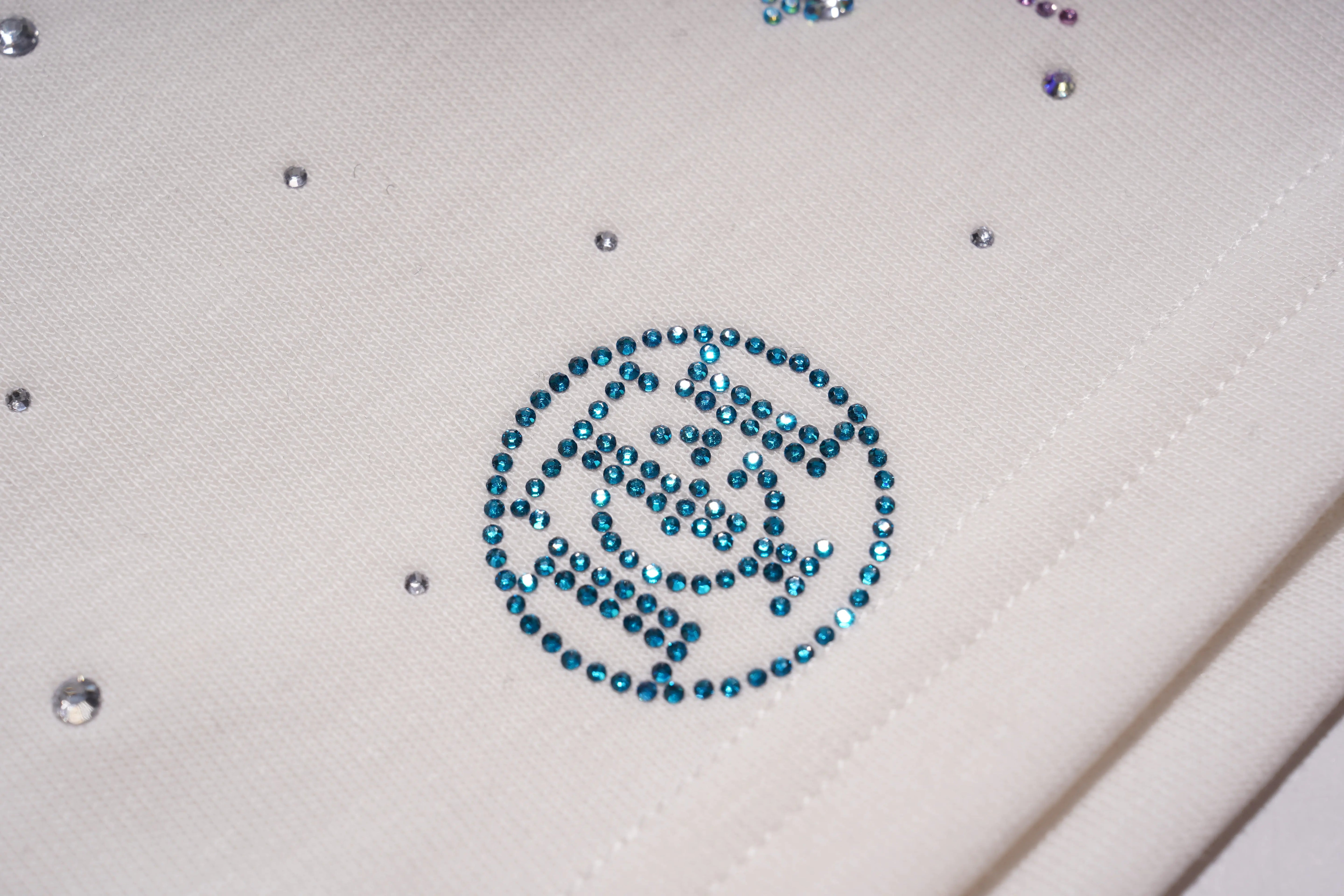 Close-up of a decorative emblem made with blue rhinestones on a white fabric background. TCH Starry Gradient Rhinestone Butterfly T-Shirt