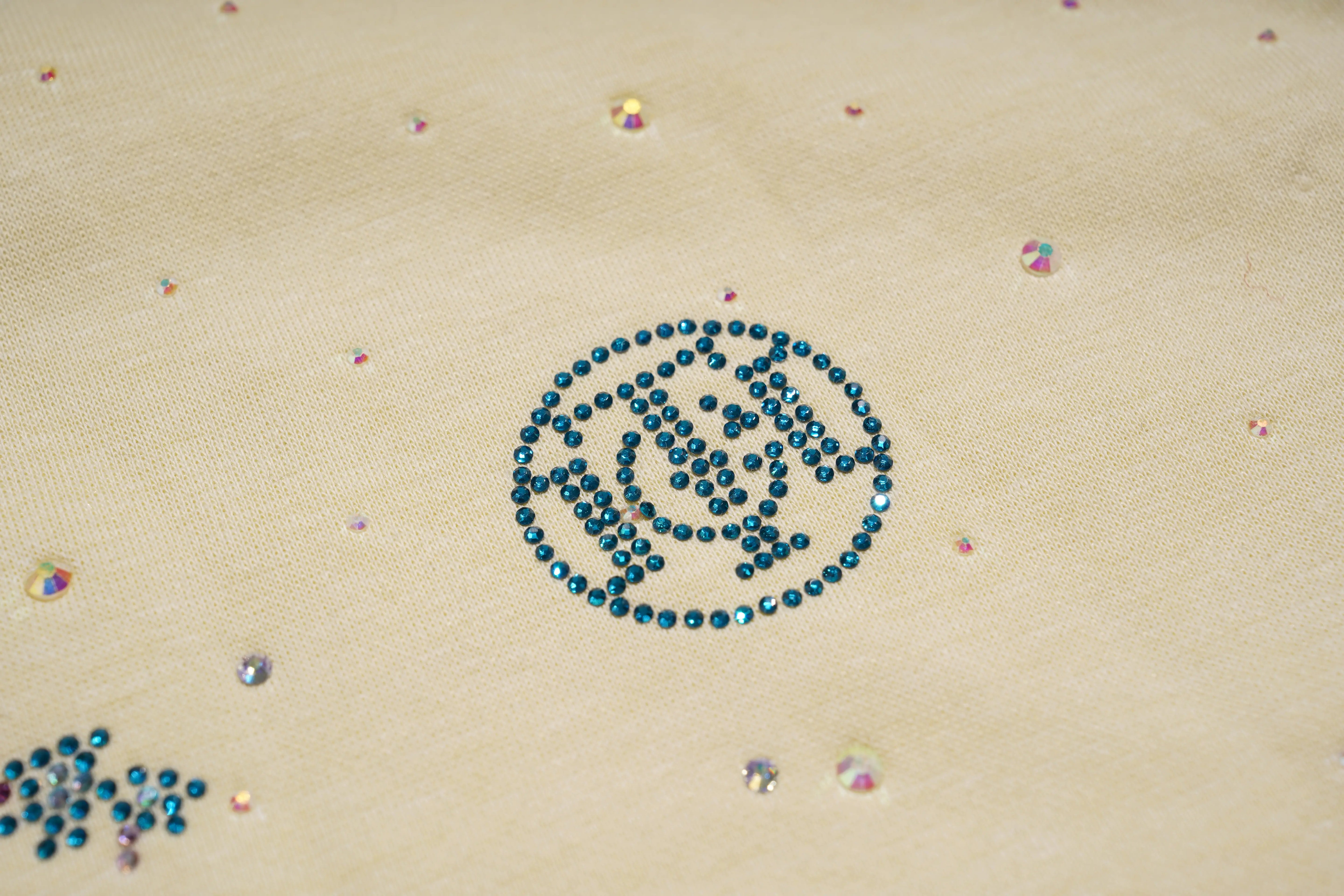 Decorative pattern of blue rhinestones on a beige fabric background, TCH Starry Gradient Rhinestone Butterfly T-Shirt
