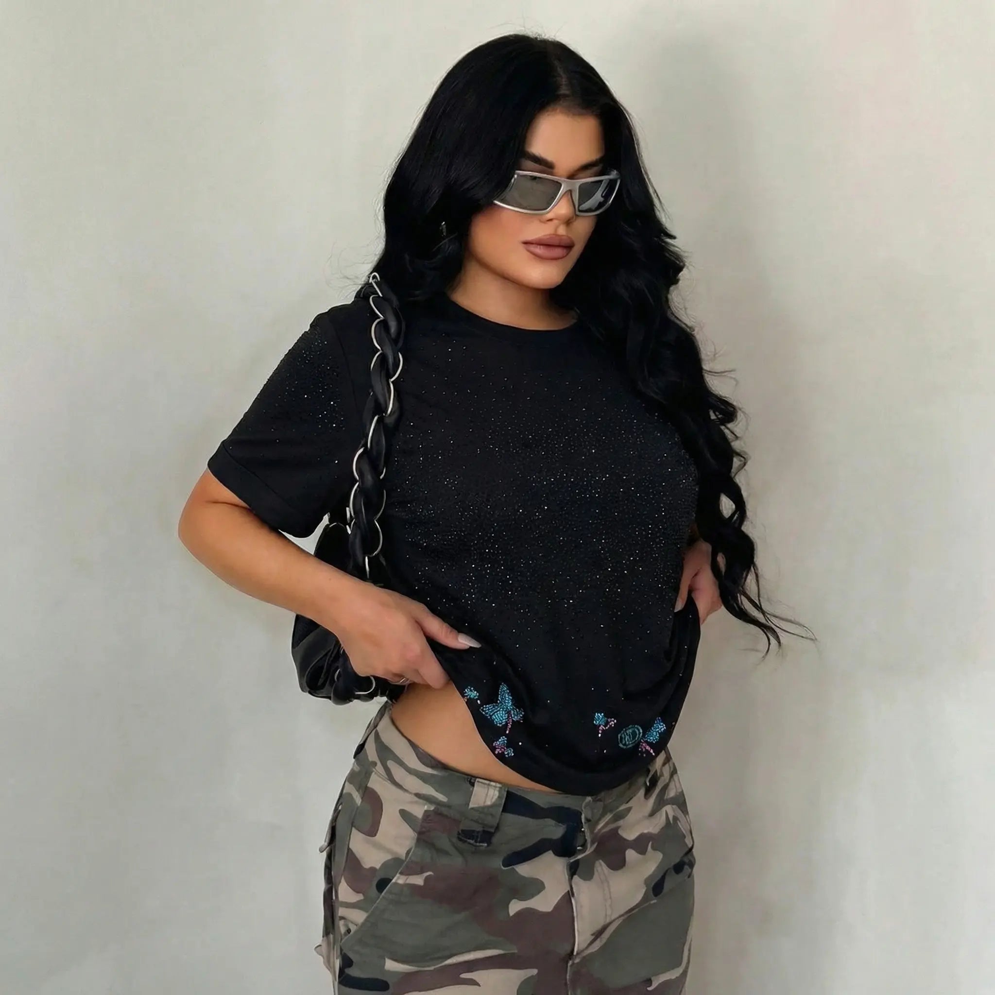 Woman wearing a black t-shirt with butterfly designs and camouflage pants against a plain background, TCH Starry Gradient Rhinestone Butterfly T-Shirt