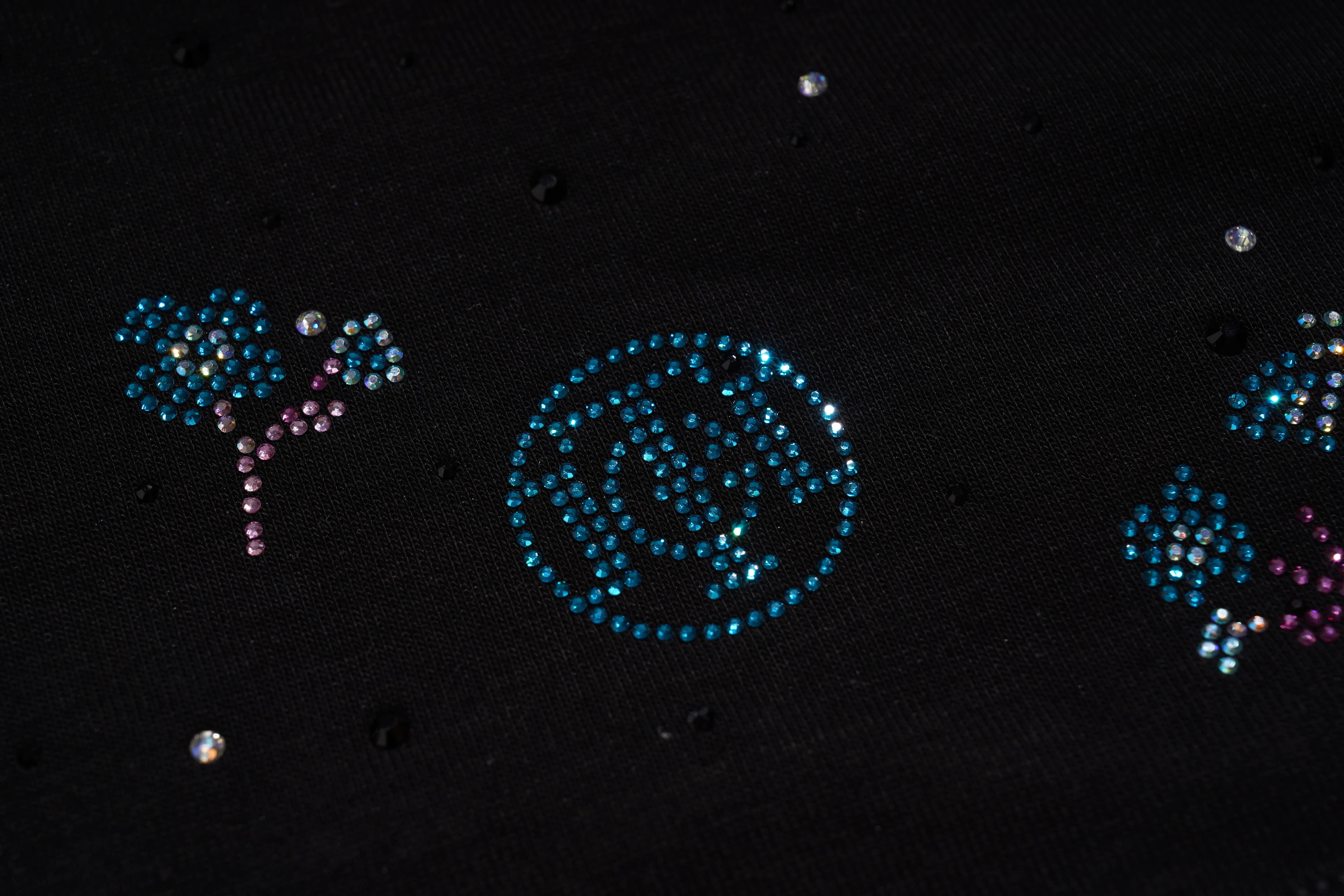 Decorative elements on a black background resembling celestial objects. TCH Starry Gradient Rhinestone Butterfly T-Shirt