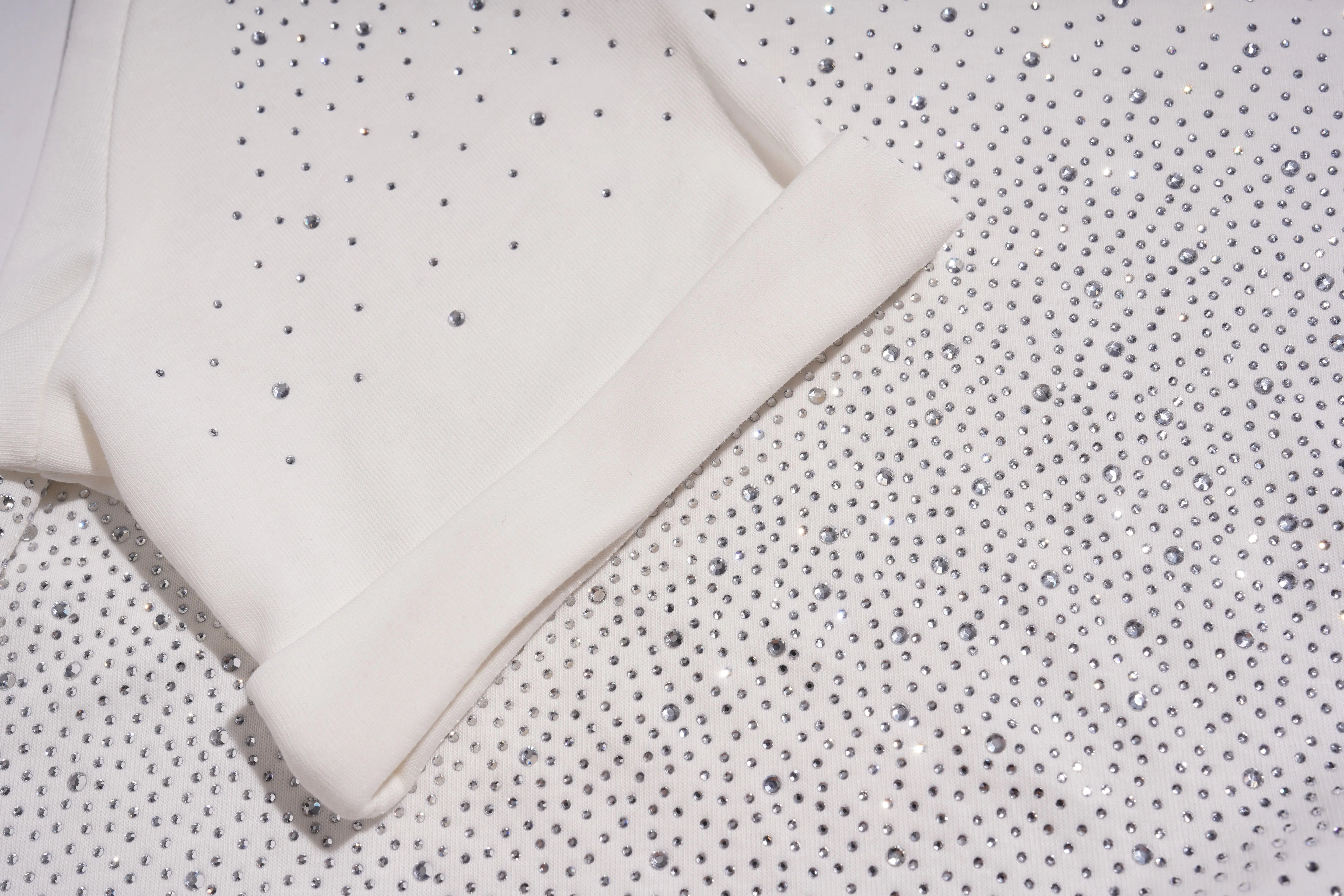 Close-up of textured fabric with a pattern of small raised dots. TCH Starry Gradient Rhinestone Butterfly T-Shirt