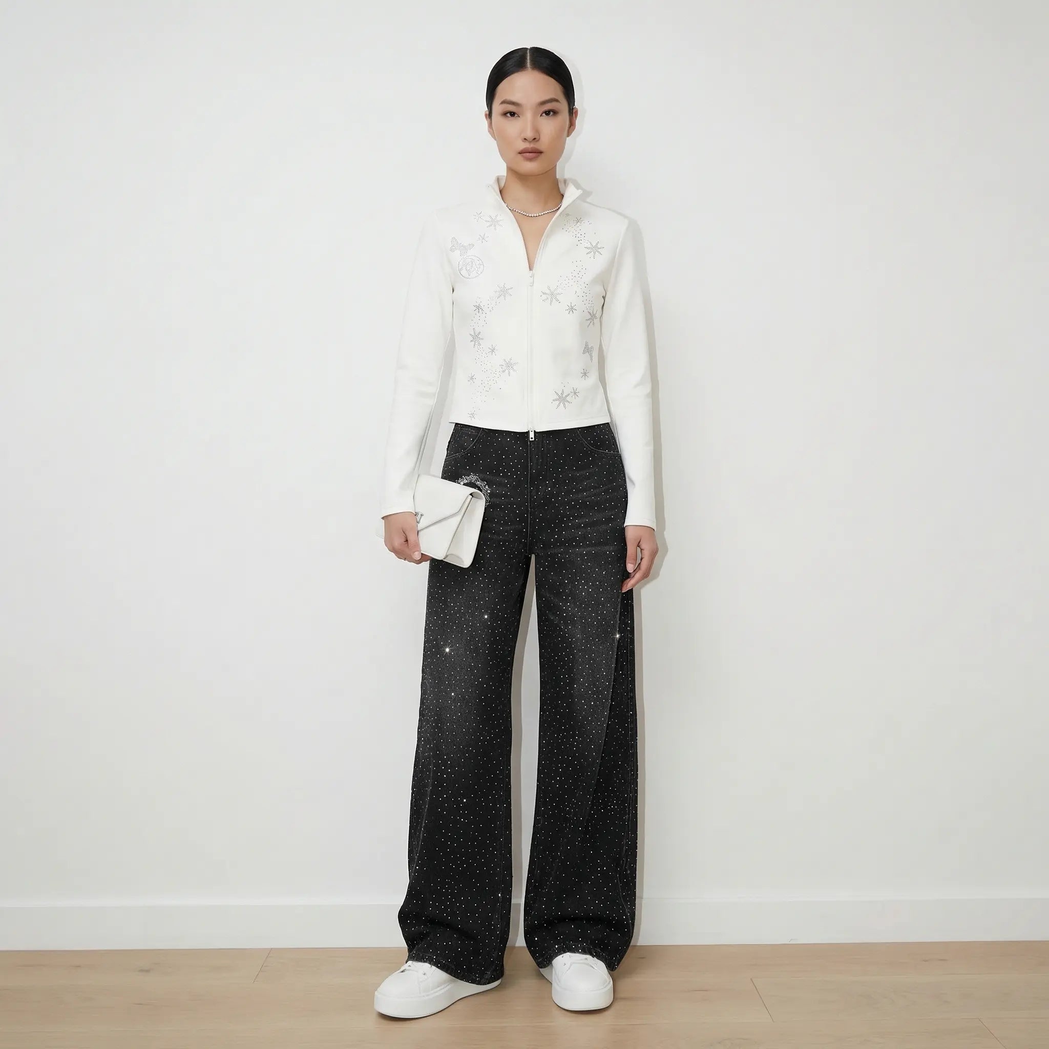 Person wearing a white blouse with black patterns and black pants against a white background, TCH Starry Rhinestone Logo Black Denim Jeans