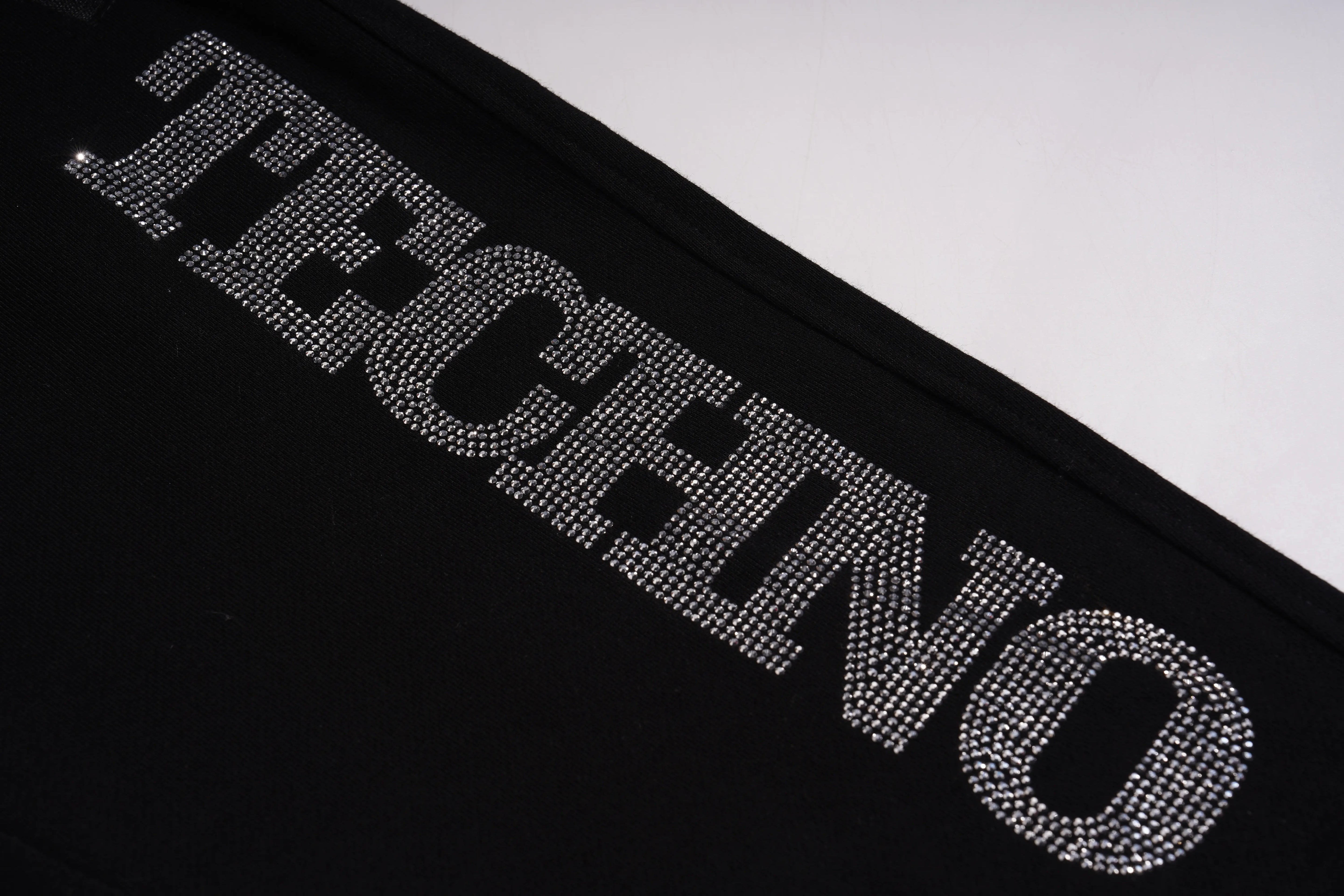 Black surface with 'TECHNO' text made of rhinestones on a white background, TCH TECHNO Rhinestone Jogger Pants