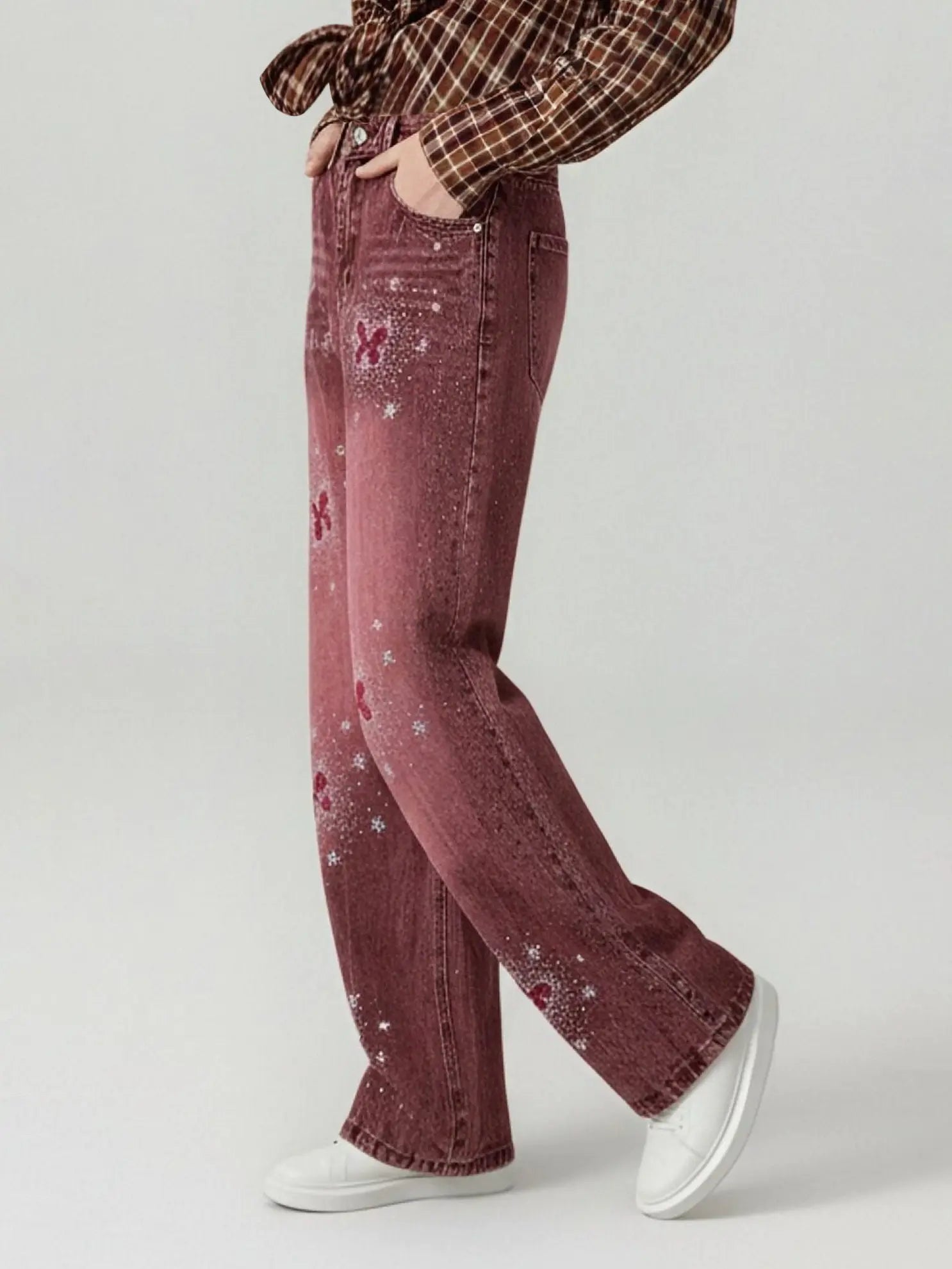 Person wearing maroon flared jeans with a plaid shirt on a light gray background, TCH Techno Butterfly Rhinestone Burgundy Jeans