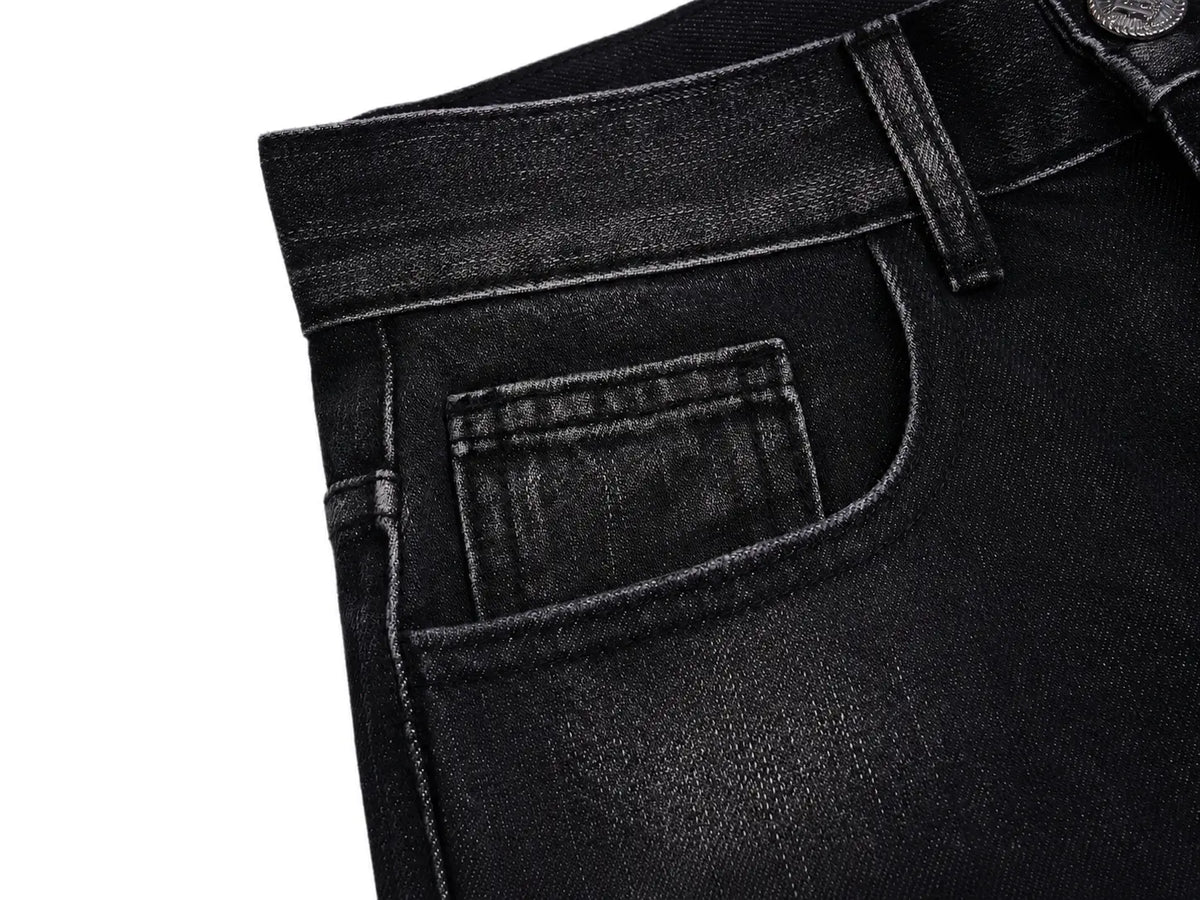 Close-up of a pair of black denim jeans showing the waistband, belt loops, and back pocket detail against a white background. TCH Techno Magic Star Graphic Wide-Leg Jeans