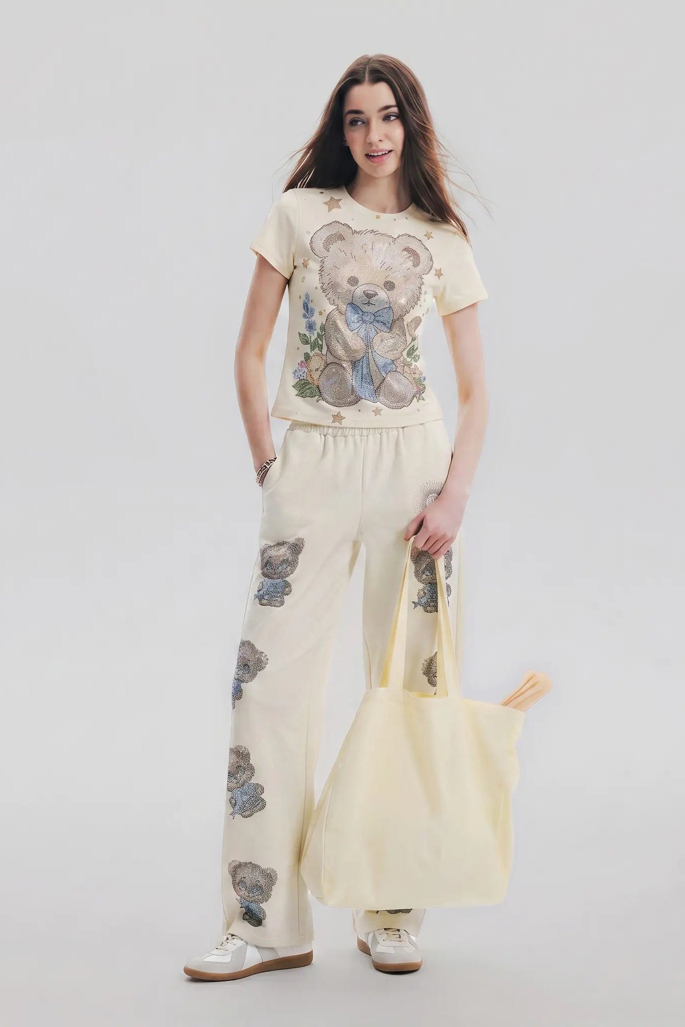 Woman wearing a matching outfit with teddy bear-themed clothing and holding a yellow bag on a plain background, TCH Teddy Bear Garden Rhinestone Lounge Set