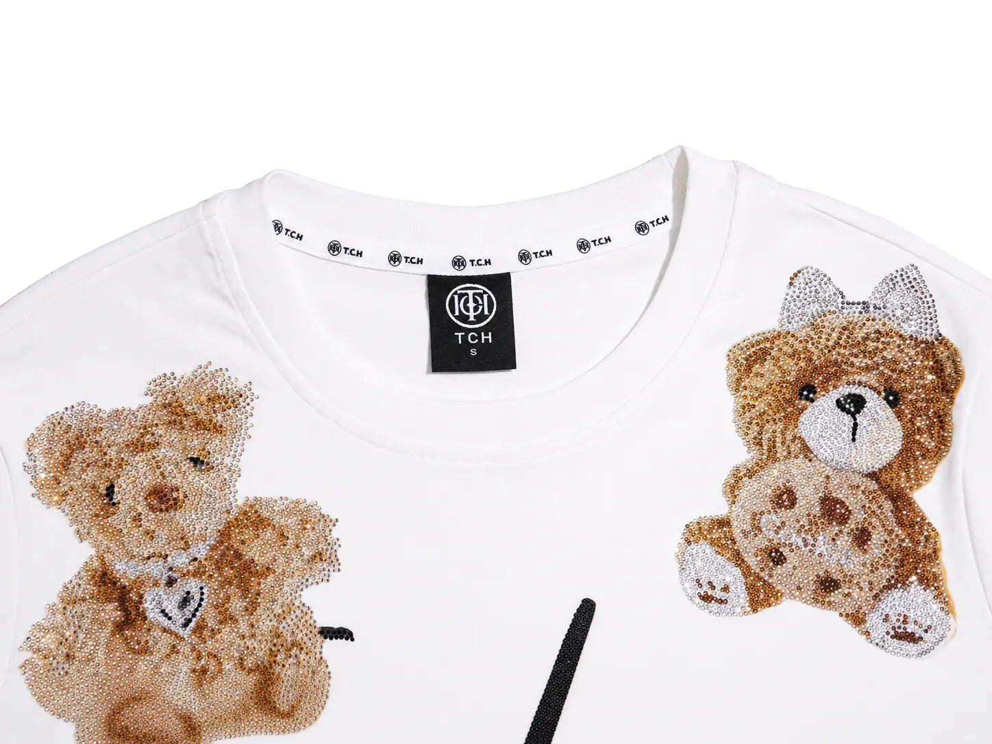 White short-sleeve crewneck T-shirt featuring two teddy bear appliqués on the front, one on each side of the chest. The shirt has a black neck label with the brand name 'TCH' repeated along the inside collar. TCH Teddy Bear Rhinestone All-Over Graphic T-Shirt