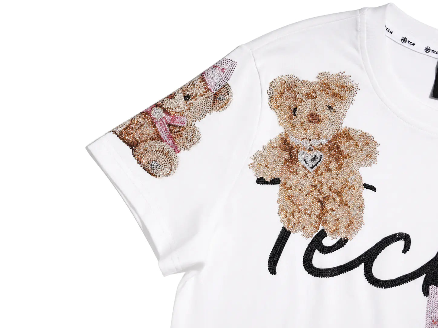 White short-sleeve T-shirt featuring a large teddy bear face and upper body made of beige sequins on the chest, with a smaller matching teddy bear on the sleeve and black script lettering below. TCH Teddy Bear Rhinestone All-Over Graphic T-Shirt