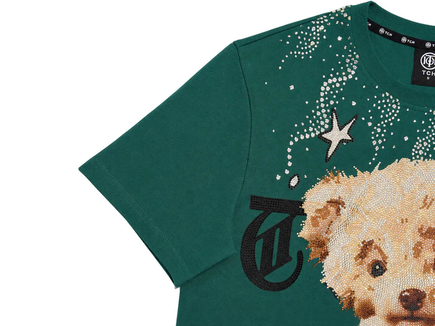 A close-up of a dark green short-sleeve T-shirt featuring a large teddy bear face and a black monogram logo on the front, embellished with rhinestones. The brand label 'TYT' is visible inside the collar. TCH Teddy Bear Rhinestone Graphic T-Shirt