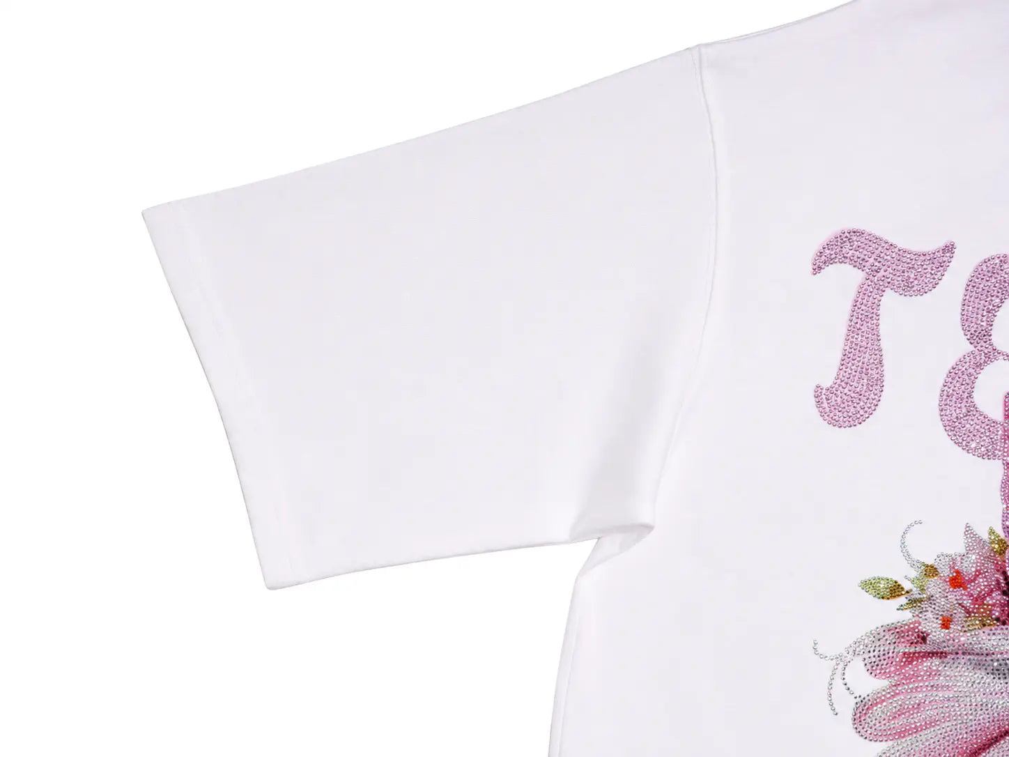 Close-up of a white short-sleeve T-shirt showing part of a pink rhinestone graphic with decorative lettering and floral embellishments on a white background. TCH Unicorn Rhinestone Angel Wings Oversized White T-Shirt