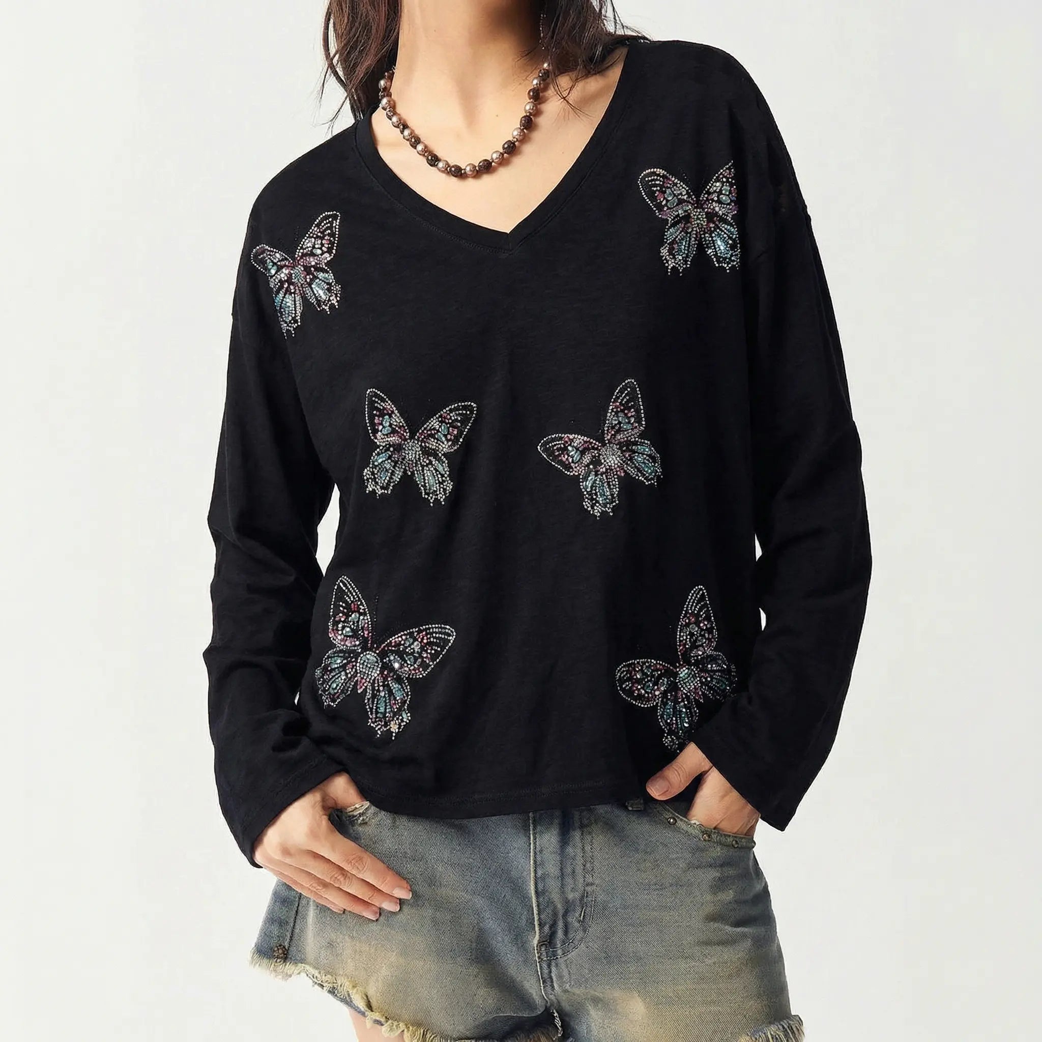Black long-sleeve top with butterfly patterns worn by a person on a white background, TCH V-Neck Rhinestone Butterfly Long Sleeve Top