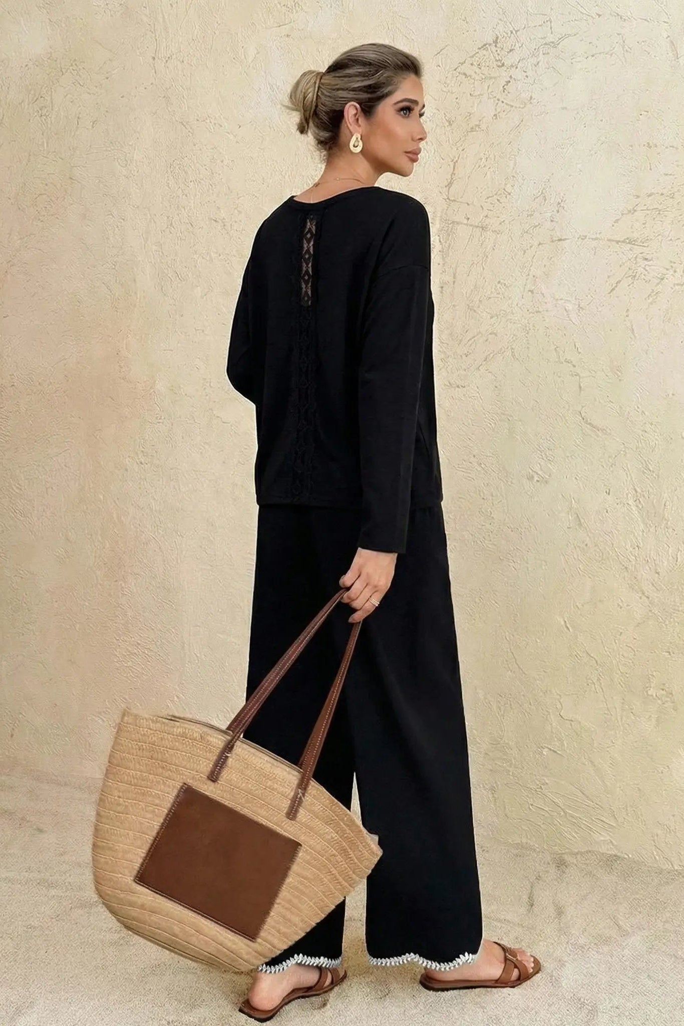 Woman in black outfit holding a brown bag against a beige wall, TCH V-Neck Rhinestone Butterfly Long Sleeve Top