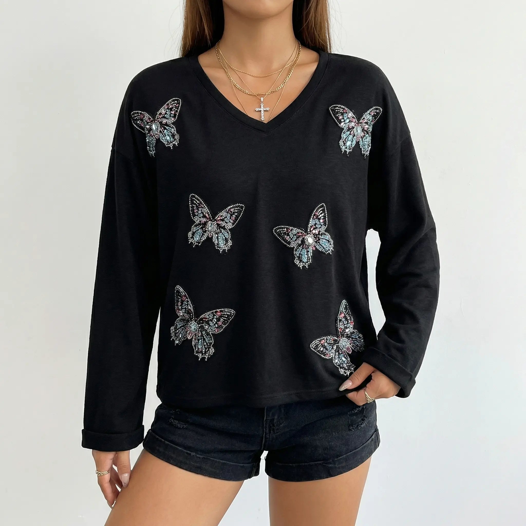 Black long-sleeve top with butterfly designs worn by a person on a plain background, TCH V-Neck Rhinestone Butterfly Long Sleeve Top