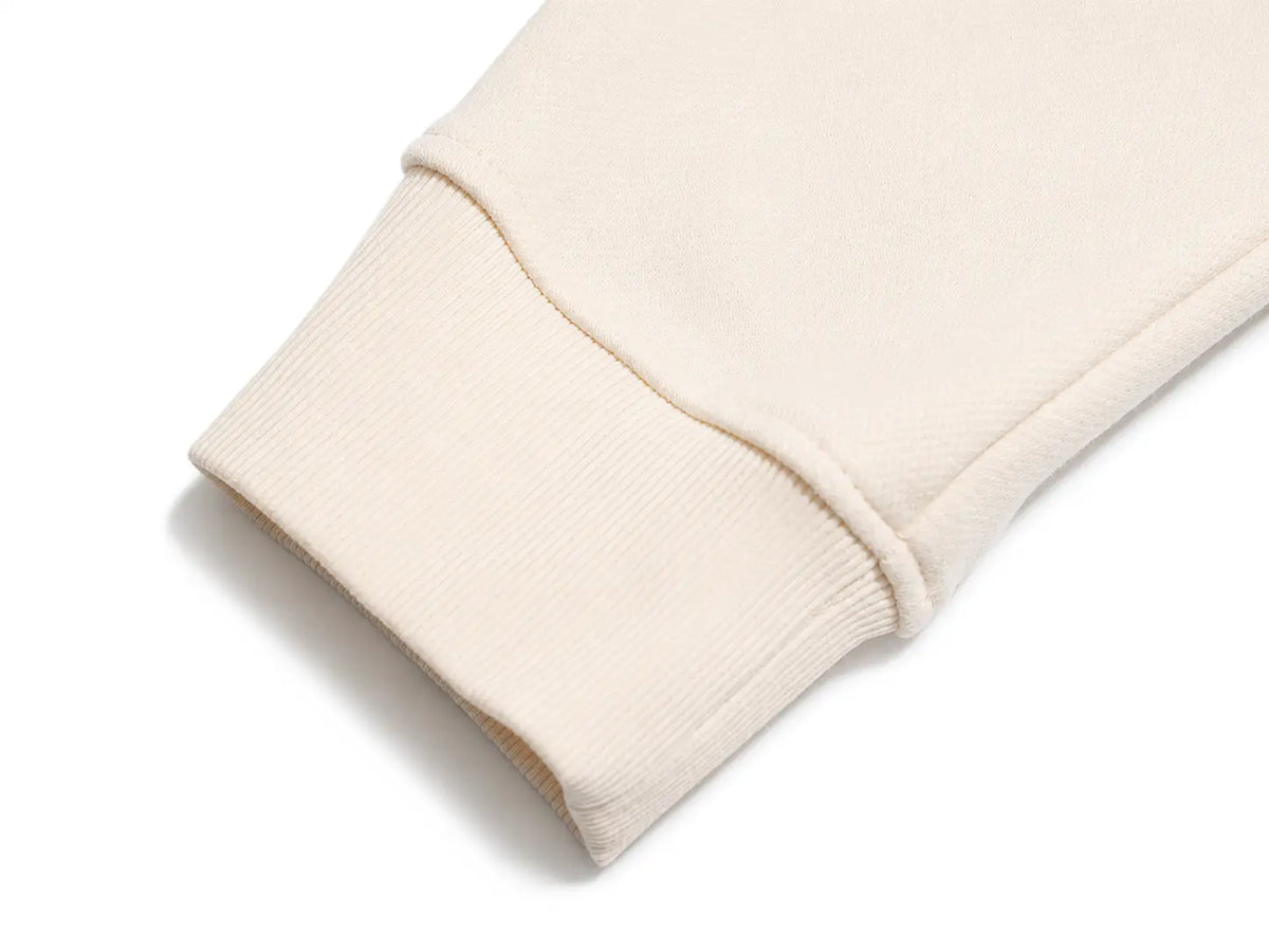 Close-up of a ribbed knit sweatshirt cuff in a light cream or off-white color, shown on a clean white background. TCH Vintage Leopard & Bird Graphic Sweatshirt