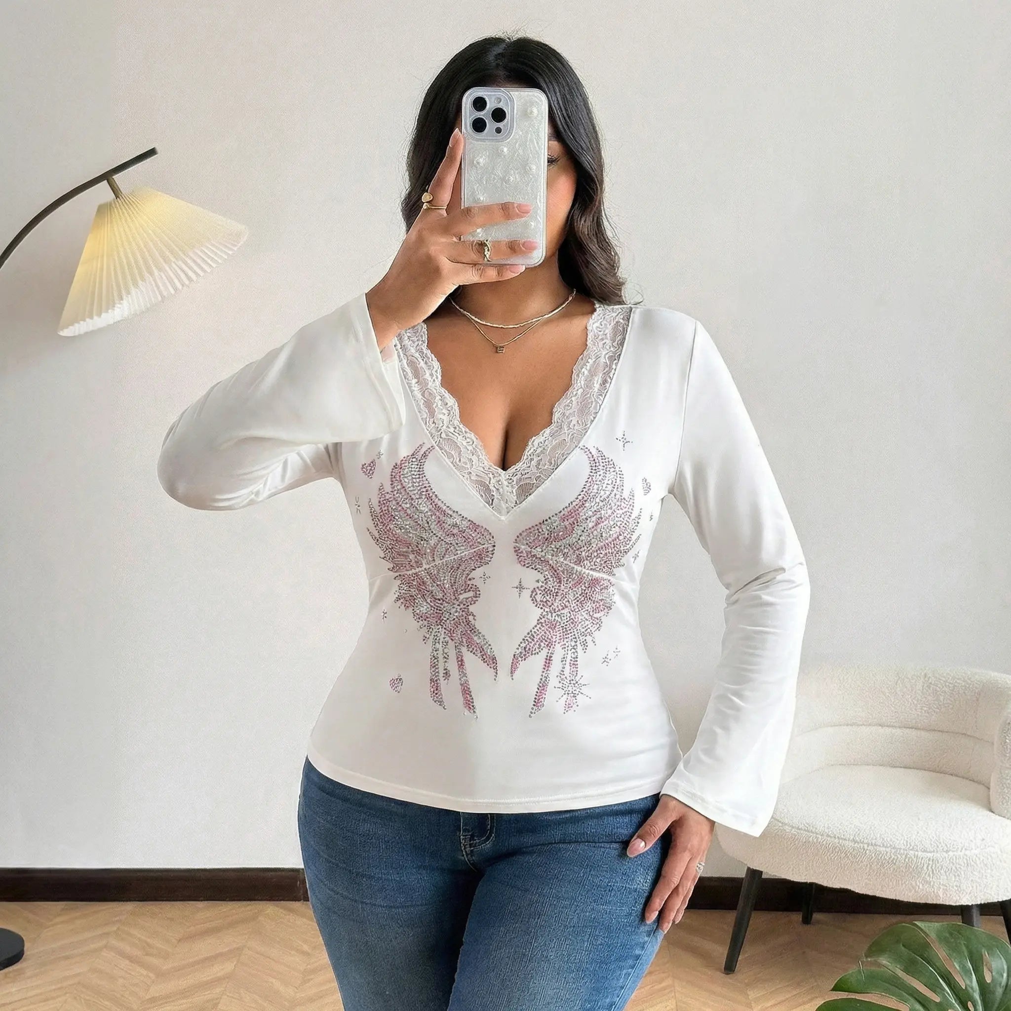 Person wearing a white long-sleeve top with lace details and blue jeans, taking a mirror selfie. TCH White Lace Trim V-Neck Rhinestone Wing Long Sleeve Top