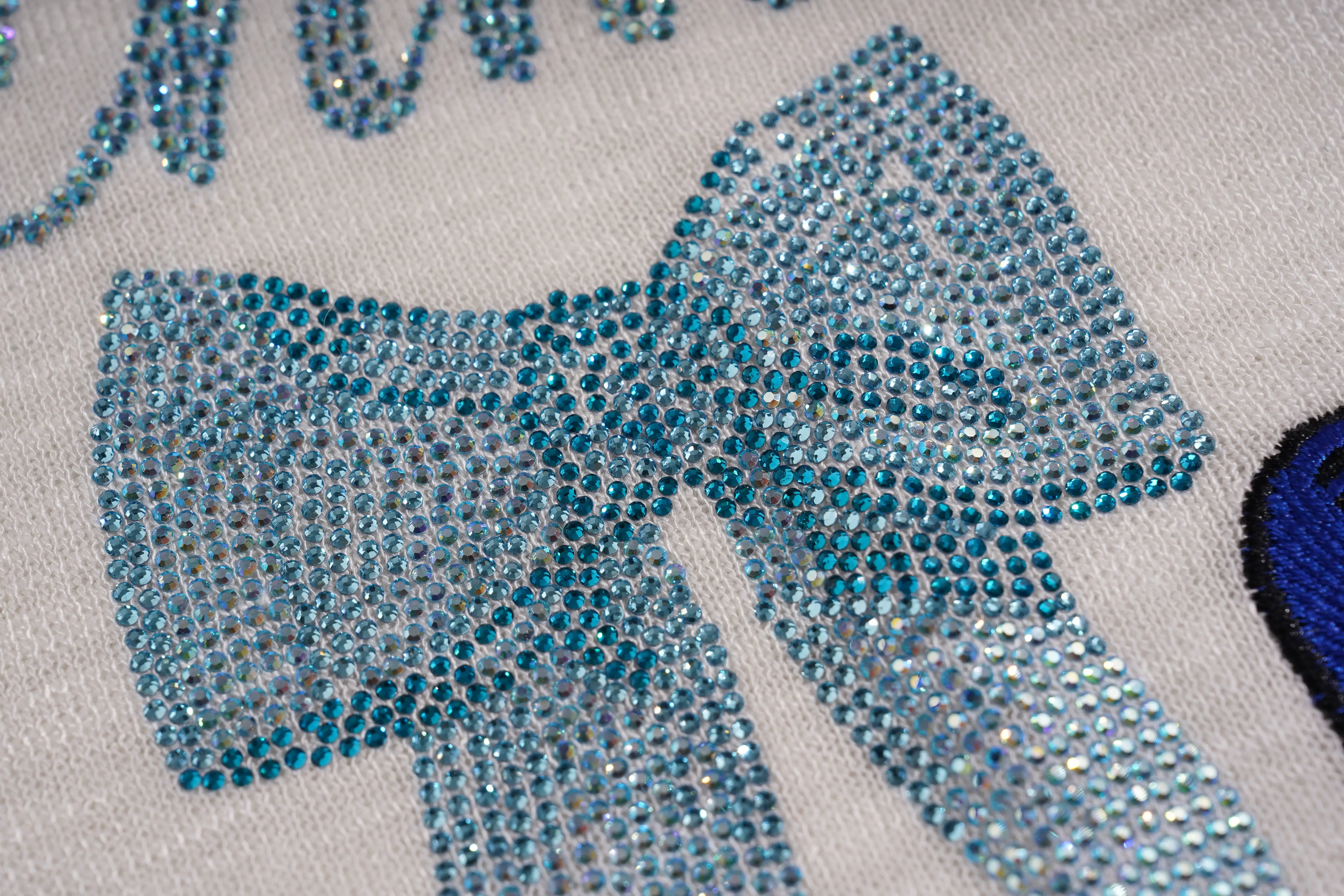 Close-up of a blue rhinestone bow on a fabric background, TCH White Rhinestone Bow Knit Cardigan