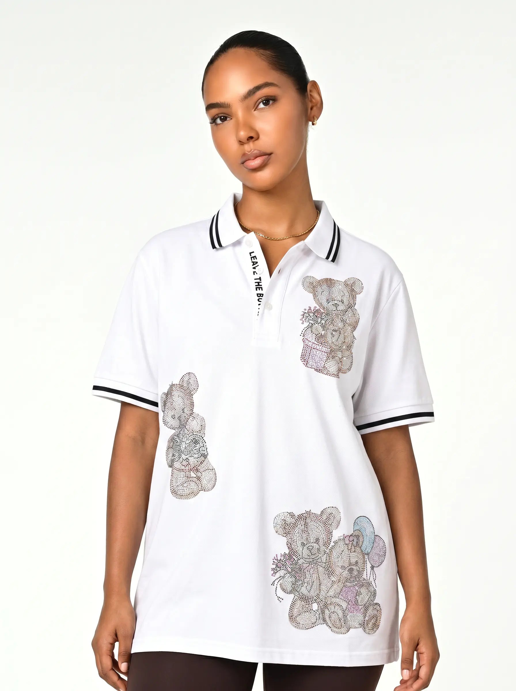 A woman modeling a white short-sleeve polo shirt with black and white striped collar and sleeve cuffs, featuring teddy bear illustrations and 'LADY BEE' text on the chest. TCH White Teddy Bear Embellished Polo Shirt