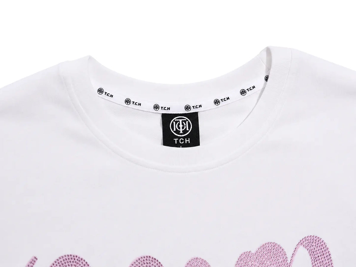 Close-up of a white crewneck t-shirt by TCH, showing the inner neck label with the brand logo and a partial pink graphic print at the bottom. TCH Women's Pink Angel Graphic Oversized T-Shirt