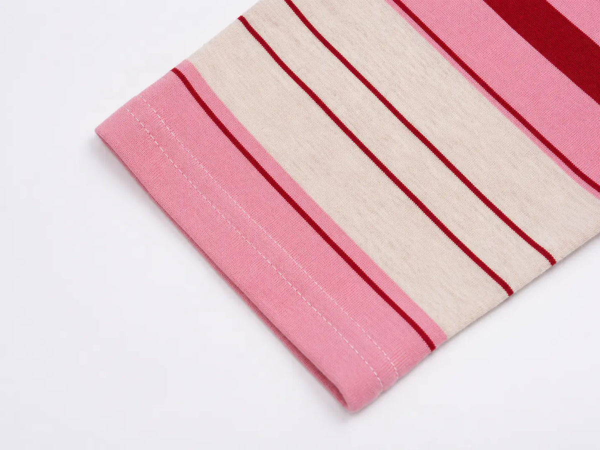 A close-up of a folded striped fabric with alternating wide pink bands and narrow cream and dark red stripes, shown on a plain white background. TCH Women's Striped Polo Mini Dress