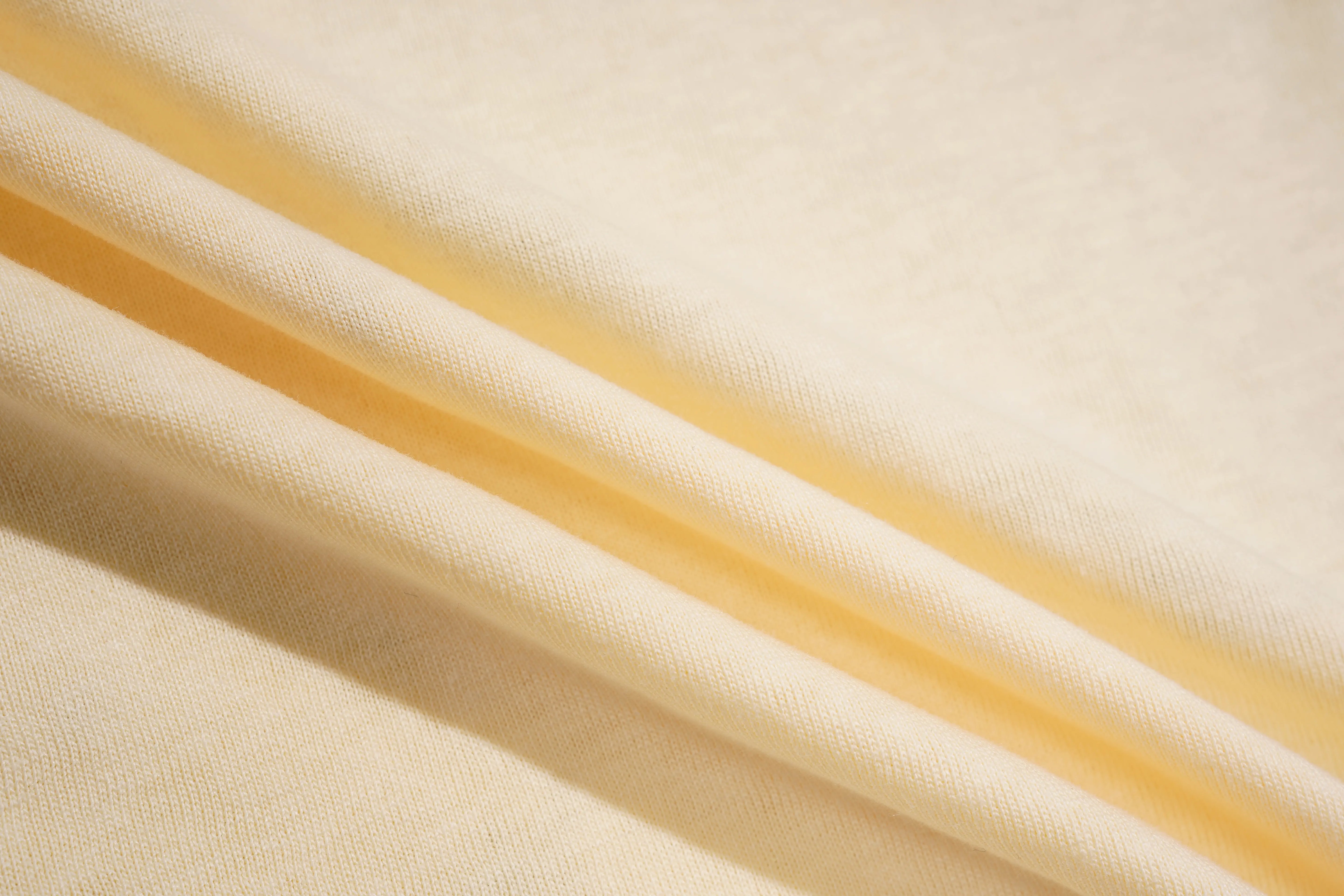 Close-up of beige fabric with a diagonal stripe, TCH Yellow Rhinestone Realistic Unicorn Graphic Bow Detail T-Shirt