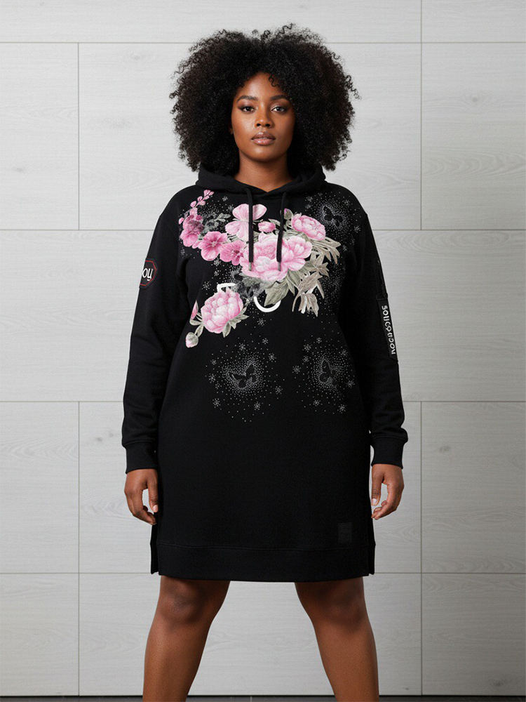 Front view of a model wearing the black TCH longline hoodie dress featuring a pink floral and butterfly graphic